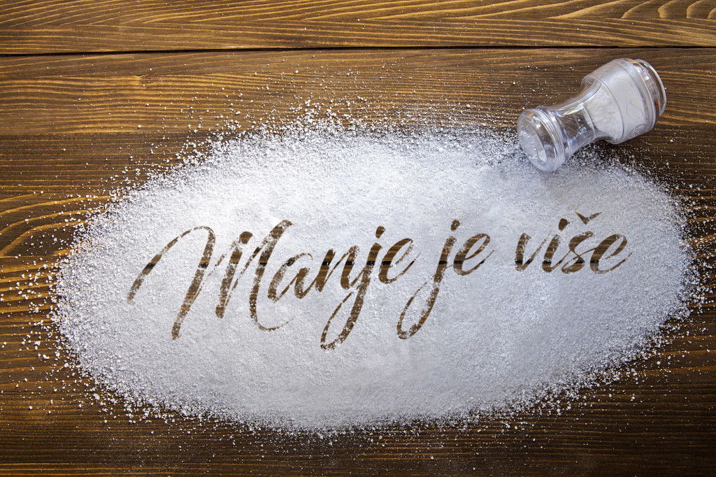 Eat less salt written on a heap of salt - antihypertensive campaign